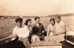 Helmer Knudsen med damer og bror ved roret i motorsjekta si. ca. 1935